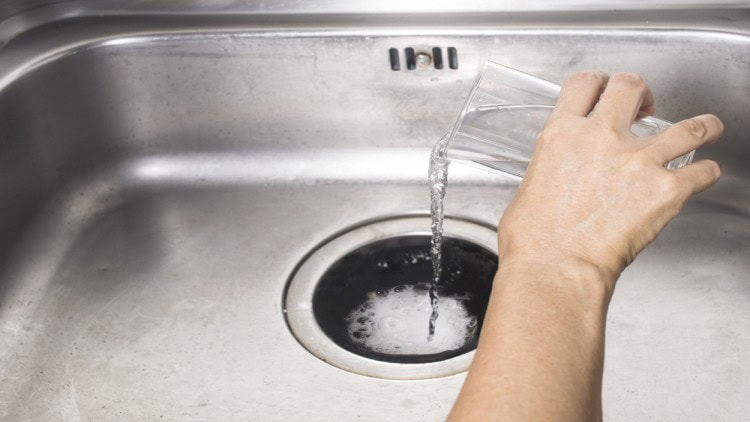 Hot water being poured into sink drain