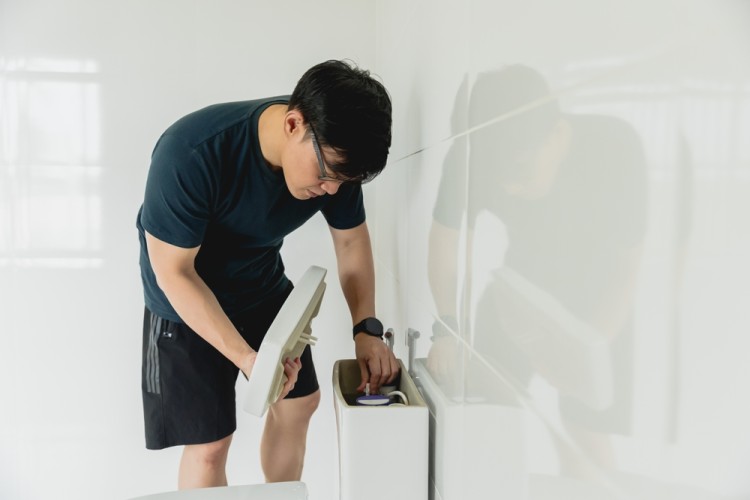 Plumber fixing blocked toilet sink